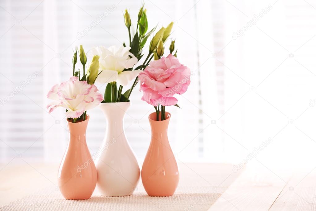 Beautiful flowers in vases with light from window — Stock Photo
