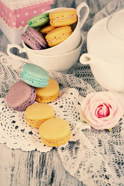 Macarons sur serviette et en tasse sur table en bois close-up — Photo