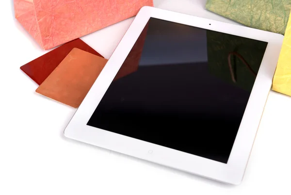 Tableta de ordenador con tarjeta de crédito y bolsas de papel en la mesa de cerca —  Fotos de Stock