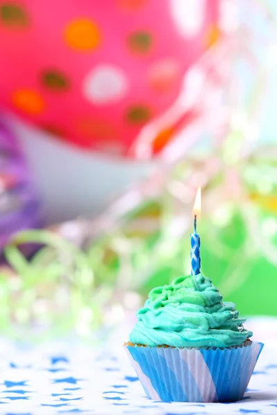 Delicioso cupcake de aniversário na mesa no fundo brilhante — Fotografia de Stock