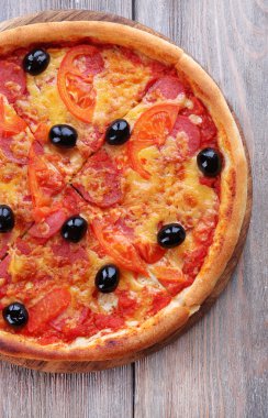 Lezzetli İtalyan pizza ahşap masa arka plan üzerinde siyah zeytin ile