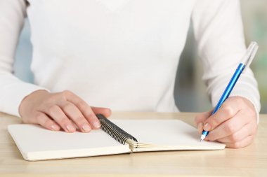 Kadın el kalem ve defter, açık renkli ahşap masaüstü