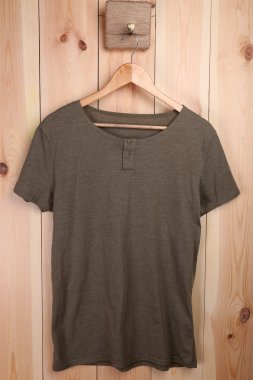 Askı üzerinde ahşap duvar arka plan üzerinde erkek t-shirt