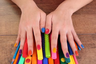 İşaretleri ve kalemleri ahşap arka plan üzerinde çok renkli kadın manikür