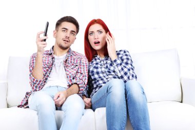 Genç çift, evde televizyon izlerken