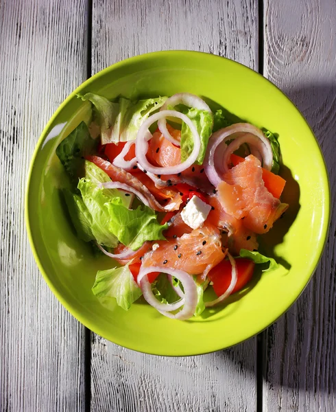 Ensalada de pescado fresco con verduras en plato sobre mesa de madera de cerca — Foto de Stock