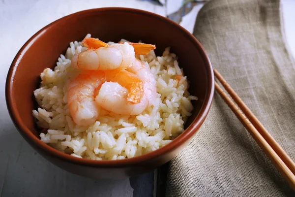 Boiled rice and shrimps in bowl, on wooden background — Stock Photo, Image