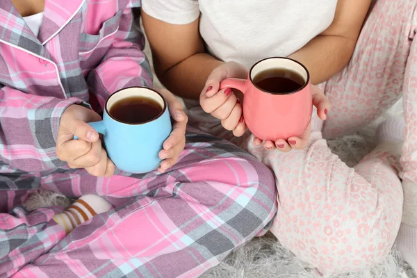 Meisjes in pyjama thuis het drinken van thee — Stockfoto