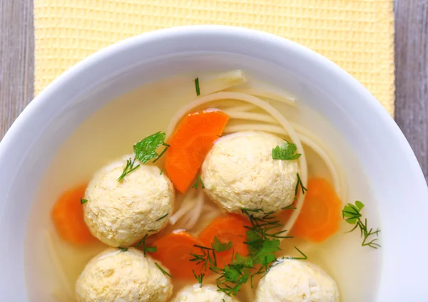 Sopa con albóndigas y fideos en tazón sobre fondo de madera — Foto de Stock