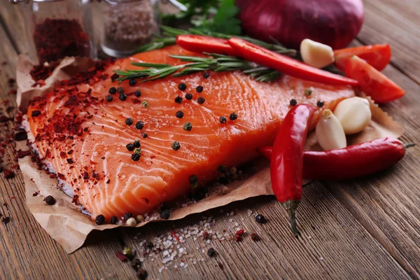 Frischer Lachs mit Gewürzen auf Holztisch — Stockfoto