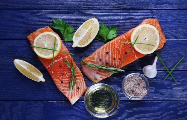 Salmão fresco com especiarias e limão na mesa de madeira — Fotografia de Stock