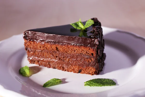 Delicious chocolate cake on plate on table — Stock Photo, Image