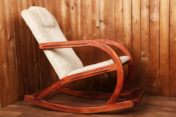 Fauteuil à bascule moderne sur fond de mur en bois — Photo