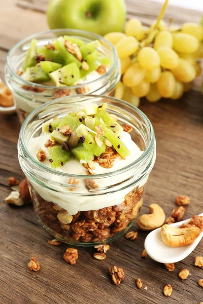 Friska skiktad dessert med müsli och frukt på bord — Stockfoto