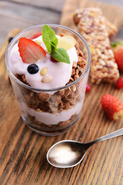 Здоровый многослойный десерт с мюсли и ягодами на столе — стоковое фото