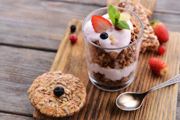 Sobremesa em camadas saudável com muesli e bagas na mesa — Fotografia de Stock