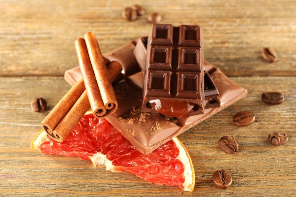 Schokolade mit Gewürzen und Grapefruitscheiben auf rustikalem Hintergrund — Stockfoto