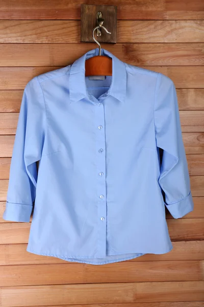 Mannelijke shirt op hanger op houten muur achtergrond — Stockfoto