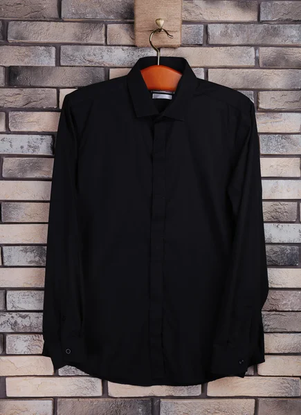 Mannelijke shirt op hanger op bakstenen muur achtergrond — Stockfoto