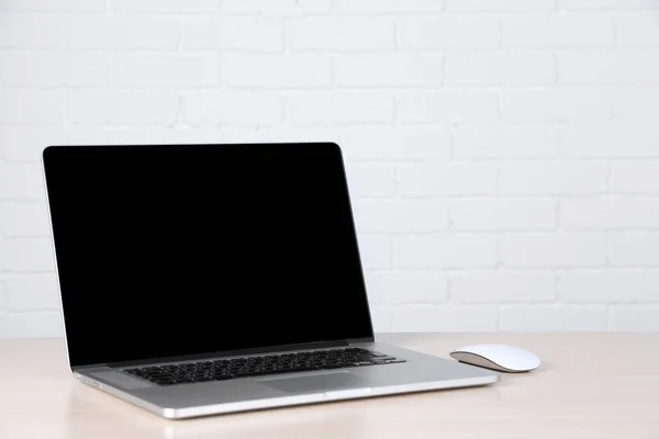 Modern laptop on table, on white wall background — Stock Photo, Image