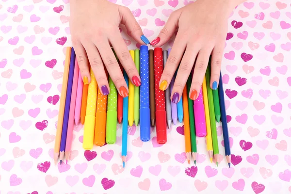 Manicure femminile multicolore con pennarelli e matite su sfondo brillante — Foto Stock