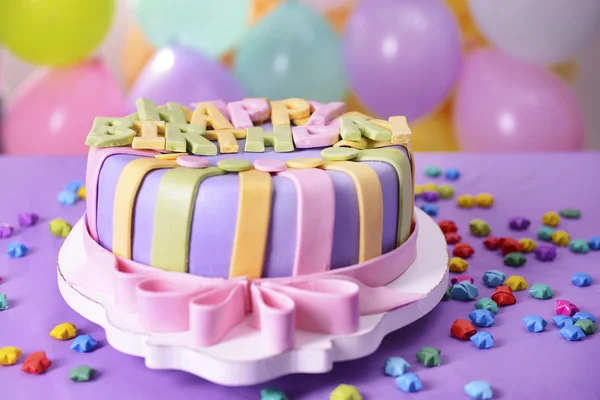 Delicioso pastel de cumpleaños en la mesa sobre fondo brillante — Foto de Stock