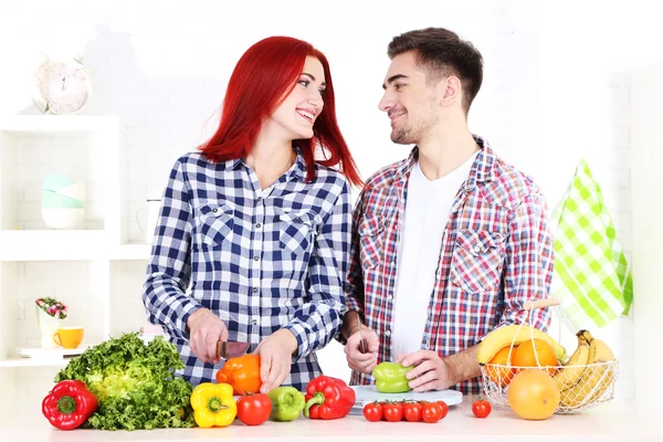 Casal feliz cortar legumes na cozinha — Fotografia de Stock