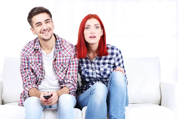 Jovem casal assistindo televisão em casa — Fotografia de Stock