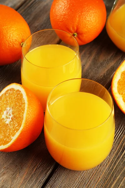 Copo de suco de laranja com fatias no fundo da mesa de madeira rústica — Fotografia de Stock