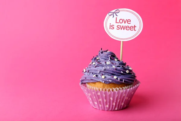 Delicioso cupcake con inscripción sobre fondo rosa — Foto de Stock