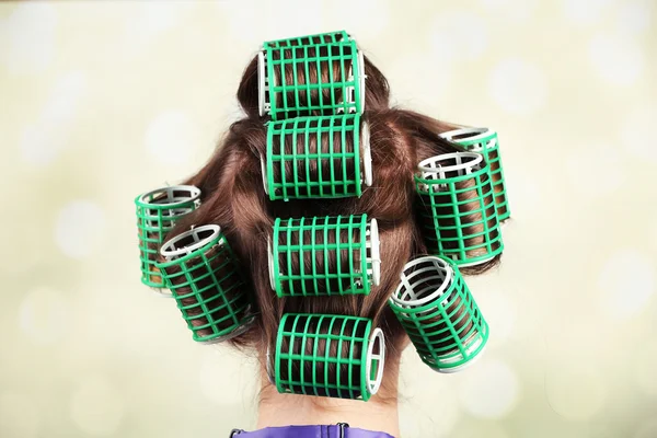 Cabello largo femenino durante el peinado con rizador, primer plano, sobre fondo claro — Foto de Stock