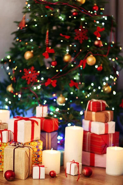 Montón de cajas de regalo bajo el árbol de Navidad en el suelo de madera, en el interior —  Fotos de Stock