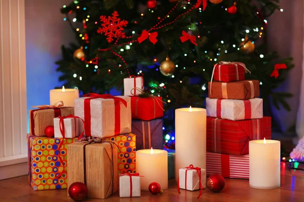 Pilha de caixas presentes sob a árvore de Natal no chão de madeira, dentro de casa — Fotografia de Stock