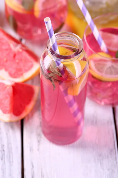 Różowa lemoniada w okularach i butelka na stół szczegół — Zdjęcie stockowe