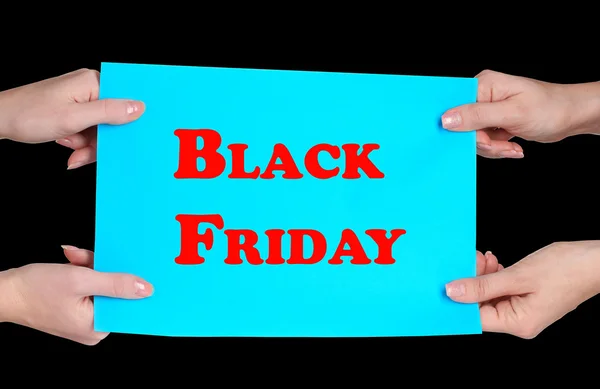 Women's hands holding advertising with Black Friday text on it isolated on black — Stock Photo, Image