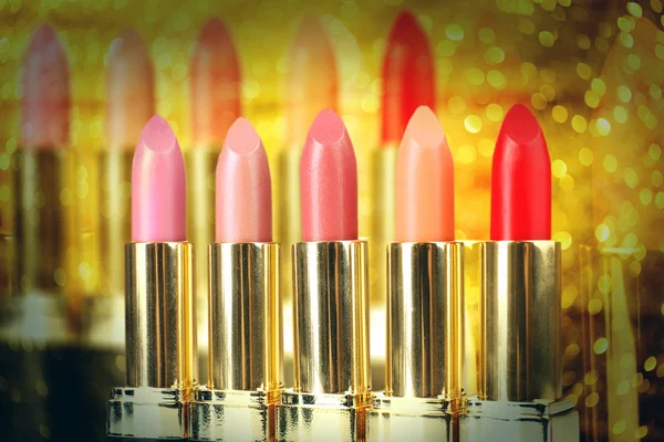 Set de lápices labiales sobre fondo dorado brillante —  Fotos de Stock