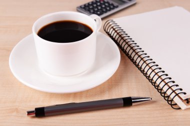Kahve daire dizüstü bilgisayar, hesap makinesi ve ahşap masa arka plan üzerinde kalem üzerinde