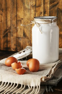 Yumurta ve yumurta kabuğu rustik ahşap zemin üzerine süt olabilir