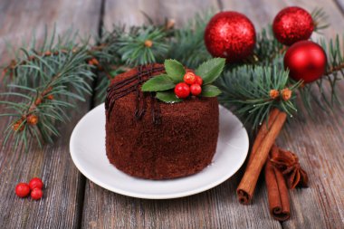 Holly ve Noel dekorasyonu ve ahşap arka plan berry ile uçan daire üzerinde lezzetli çikolatalı kek