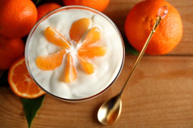 Lezzetli süt tatlı taze mandalina adet ahşap arka plan üzerinde cam kase