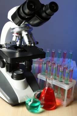 Mikroskop ve masaya renk arka plan üzerinde test tüpleri
