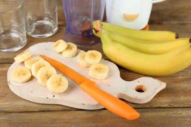 Ahşap arka plan üzerinde kesme tahtası üzerinde muz dilimlenmiş