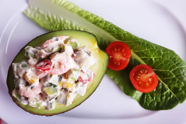 Tasty salad in avocado on plate close-up — Stock Photo, Image