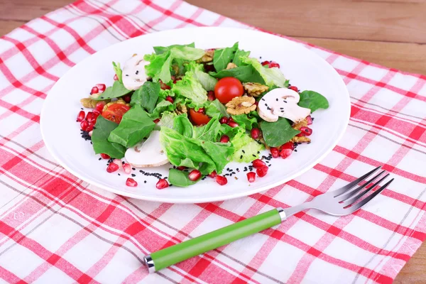 Frischer Salat mit Gemüse, Granat und Gewürzen auf dem Teller in Großaufnahme — Stockfoto