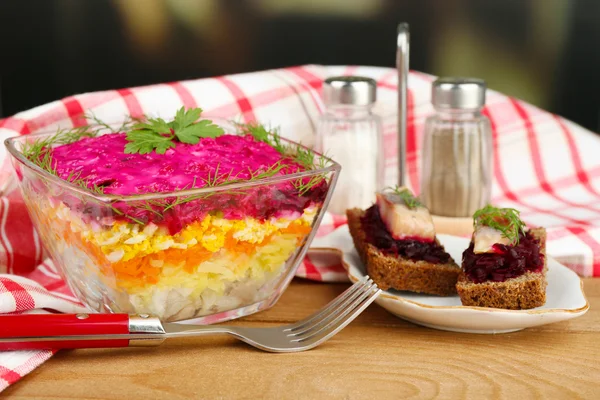 Russisk sildesalat i glassbolle på trebord, på lys bakgrunn – stockfoto