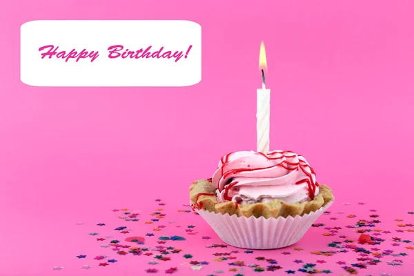 Birthday cup cake with candle and colorful stars on pink background — Stock Photo, Image