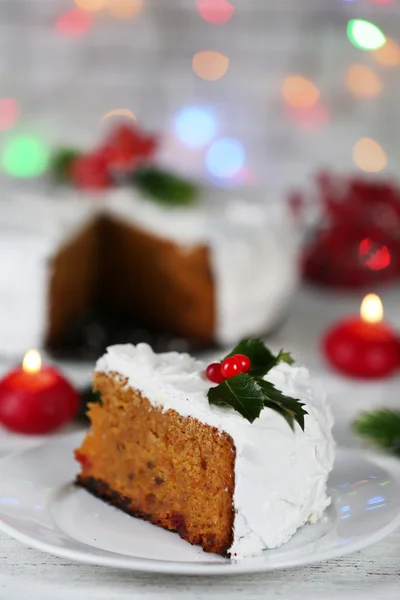 Rebanada de crema cubierta de pastel con decoración de Navidad en la mesa, sobre fondo brillante —  Fotos de Stock