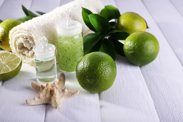 Spa composition with lime and towel color wooden background — Stock Photo, Image