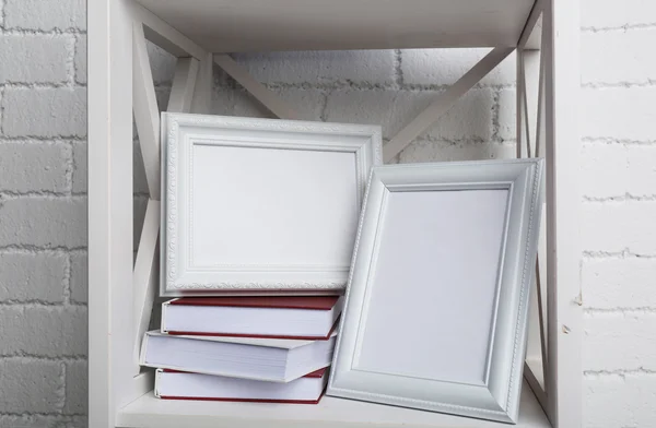 Marcos de fotos con libros en estante, sobre fondo de pared de ladrillo — Foto de Stock