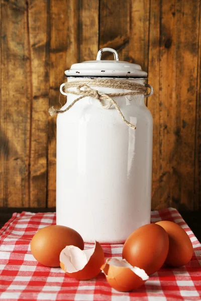 牛奶可以用鸡蛋和蛋壳仿古木制背景上的餐巾 — 图库照片
